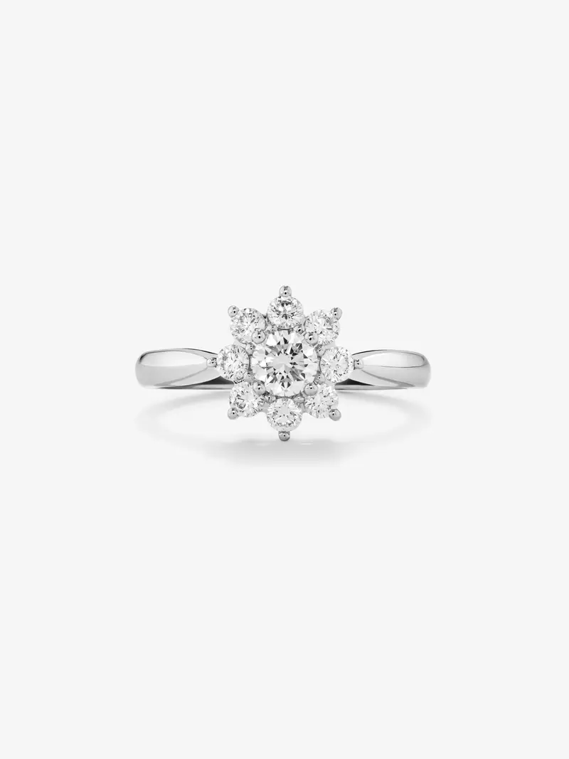 Anillo de oro blanco de 18K con diamante central en talla brillante de 0,2 cts y orla de 8 diamantes en talla brillante con forma de estrella