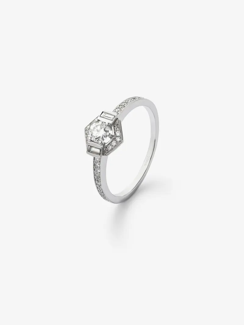 Anillo de oro blanco de 18K con diamante central en talla brillante de 0,2cts, dos diamantes en talla baguette con un total de 0,05cts y diamantes en talla brillante con un total de 0,12cts