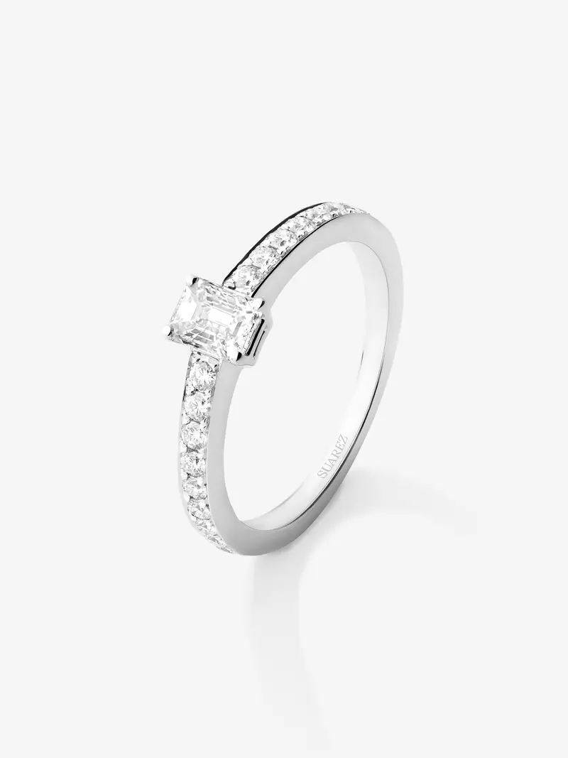 Anillo de oro blanco de 18K con diamante central en talla esmeralda de 0,4 cts y brazo de 26 diamantes en talla brillante con un total de 0,26 cts