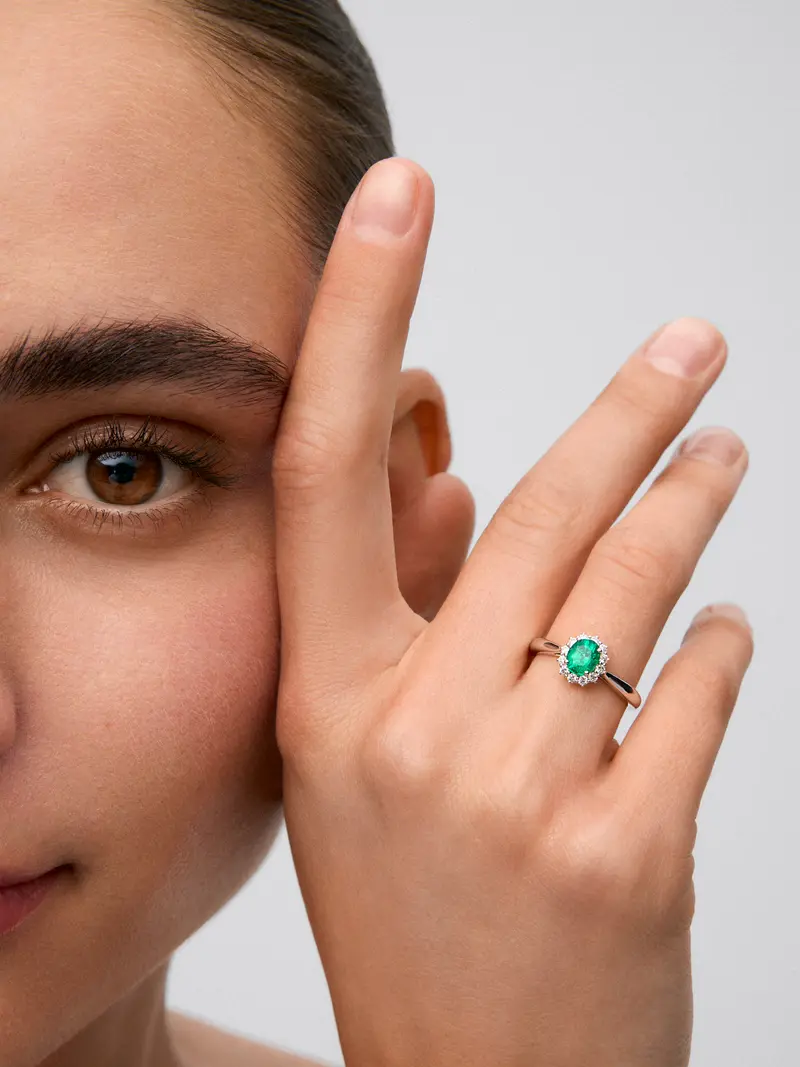 Anillo de oro blanco de 18K con esmeralda verde en talla oval de 0,5 cts y diamantes en talla brillante con un total de 0,21 cts