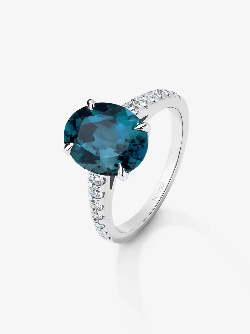 Anillo de oro blanco de 18K con topacio azul london en talla oval de 4,25 cts y 14 diamantes en talla brillante con un total de 0,32 cts