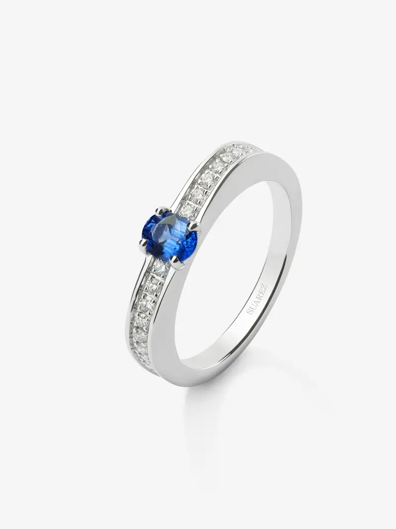 Anillo de oro blanco de 18K con zafiro azul en talla oval de 0,40 cts y 22 diamantes en talla brillante con un total de 0,19 cts