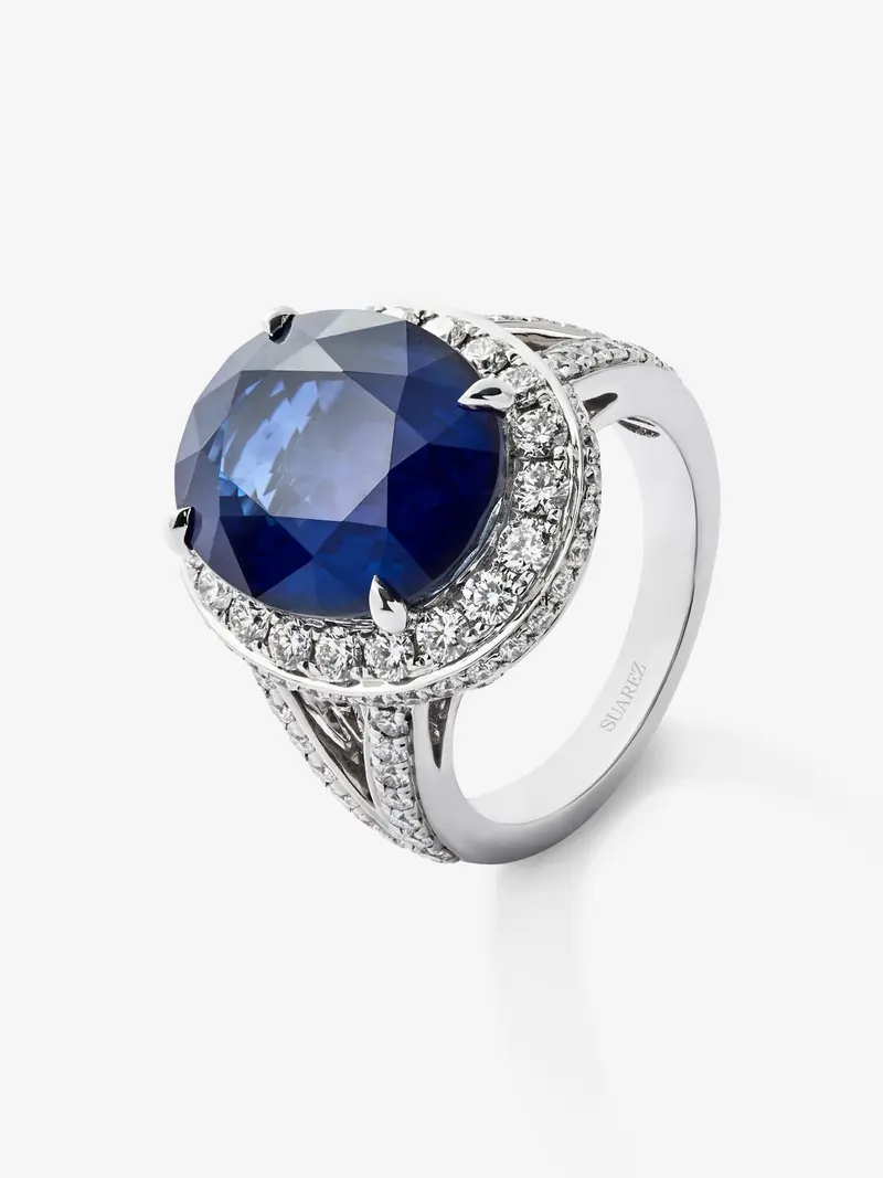 Anillo de oro blanco de 18K con zafiro azul royal en talla oval de 12,64 cts y orla y brazo de 93 diamantes con un total de 1,74 cts