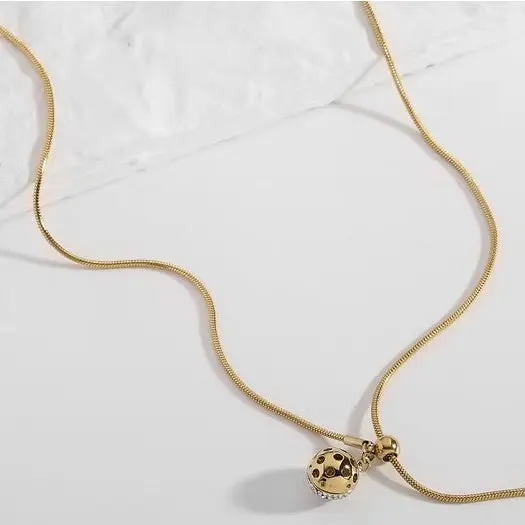 Collar de acero ajustable con dije esférico con circonitas acabado oro