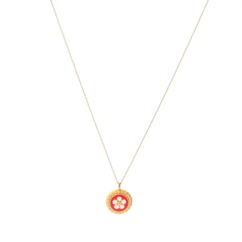 Collar de acero con charm de flor con texturas y fondo rojo oro