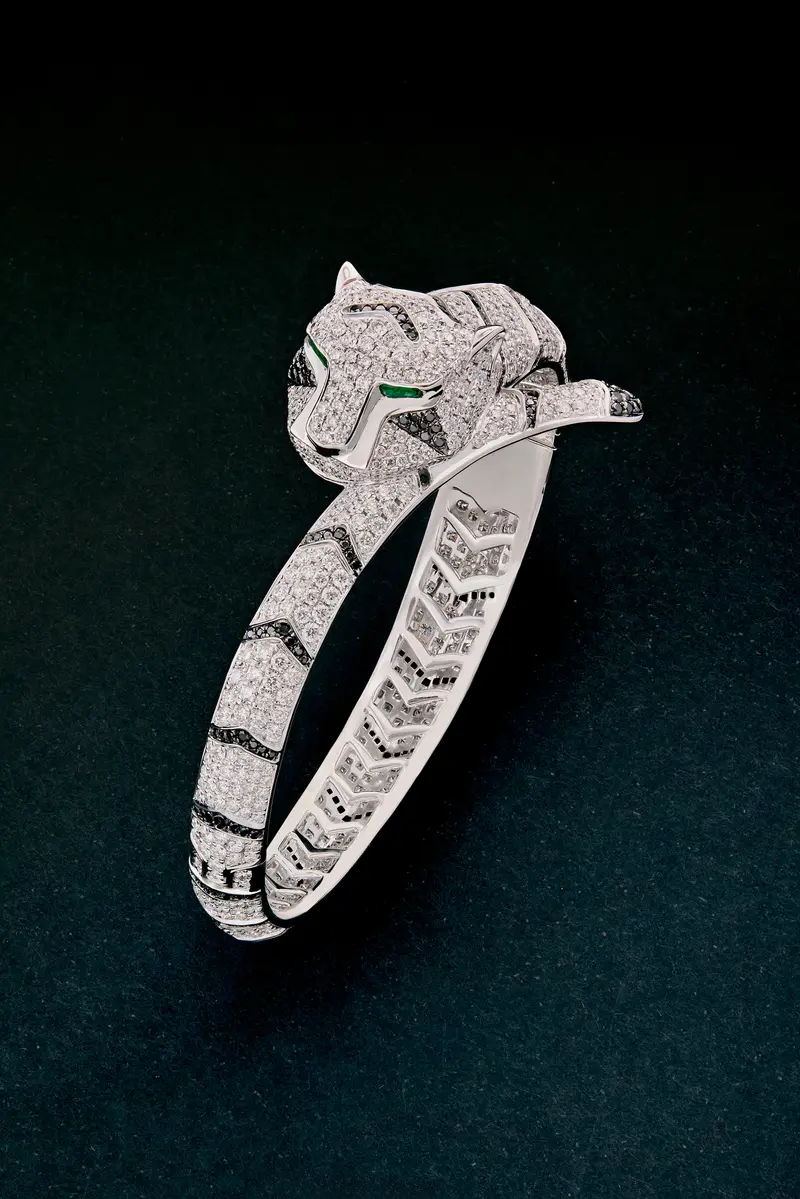 Pulsera rígida con forma de tigre en oro blanco de 18K con diamantes blancos y negros en talla brillante con un total de 9,66 cts y esmeraldas en talla trapecio con un total de 0,13 cts